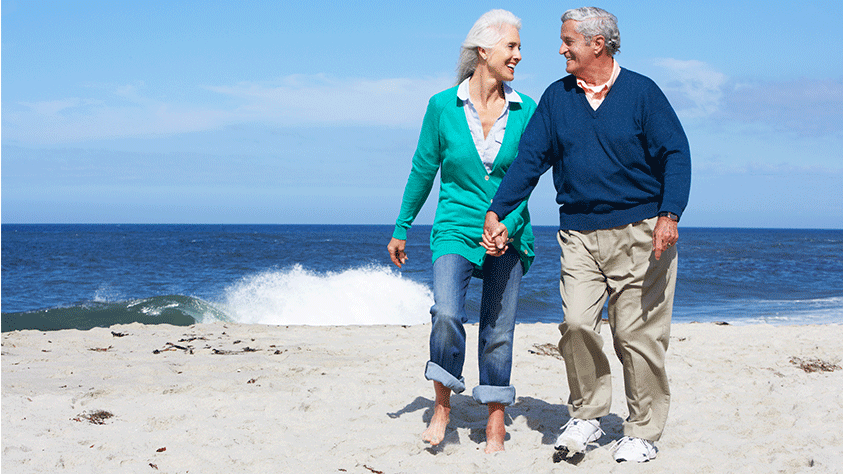 older couple walking on the beach